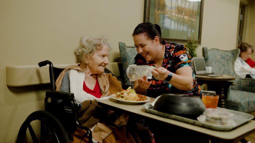 A woman at a long term care facility is assisted by a nurse who specializes in skilled nursing